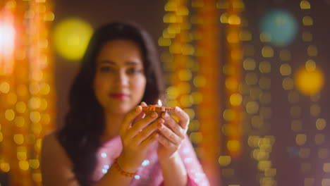 Frau-Feiert-Das-Diwali-Fest-Und-Hält-Eine-Beleuchtete-Diya-Öllampe-In-Richtung-Kamera